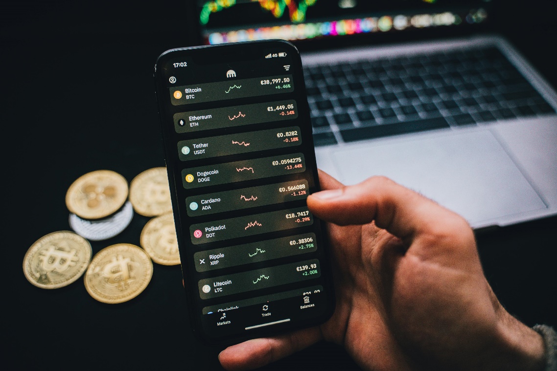 risk management digital assets smartphone trading Person holding a smartphone displaying crypto trading graphs